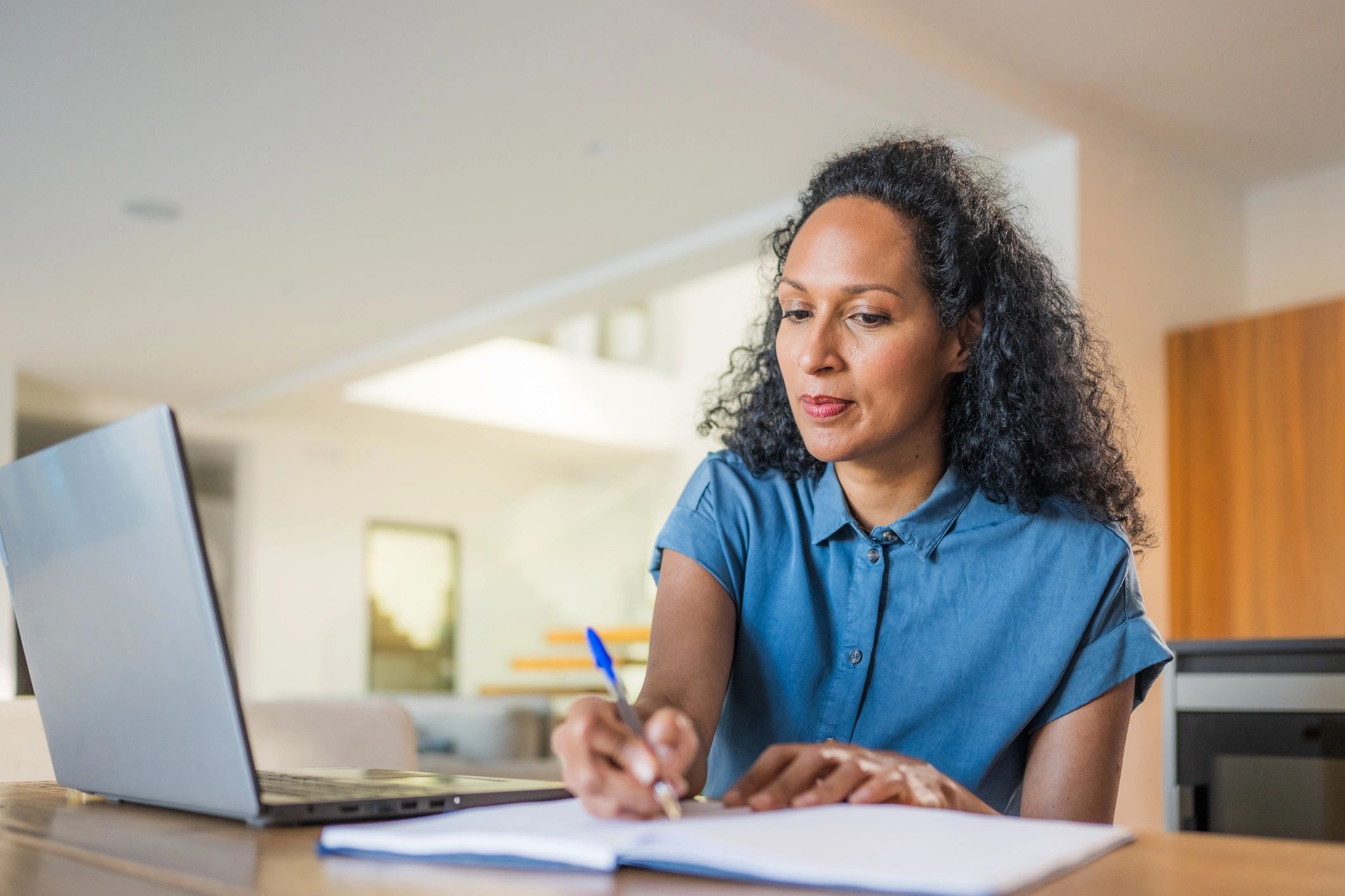 Person taking notes while working on an assessment report