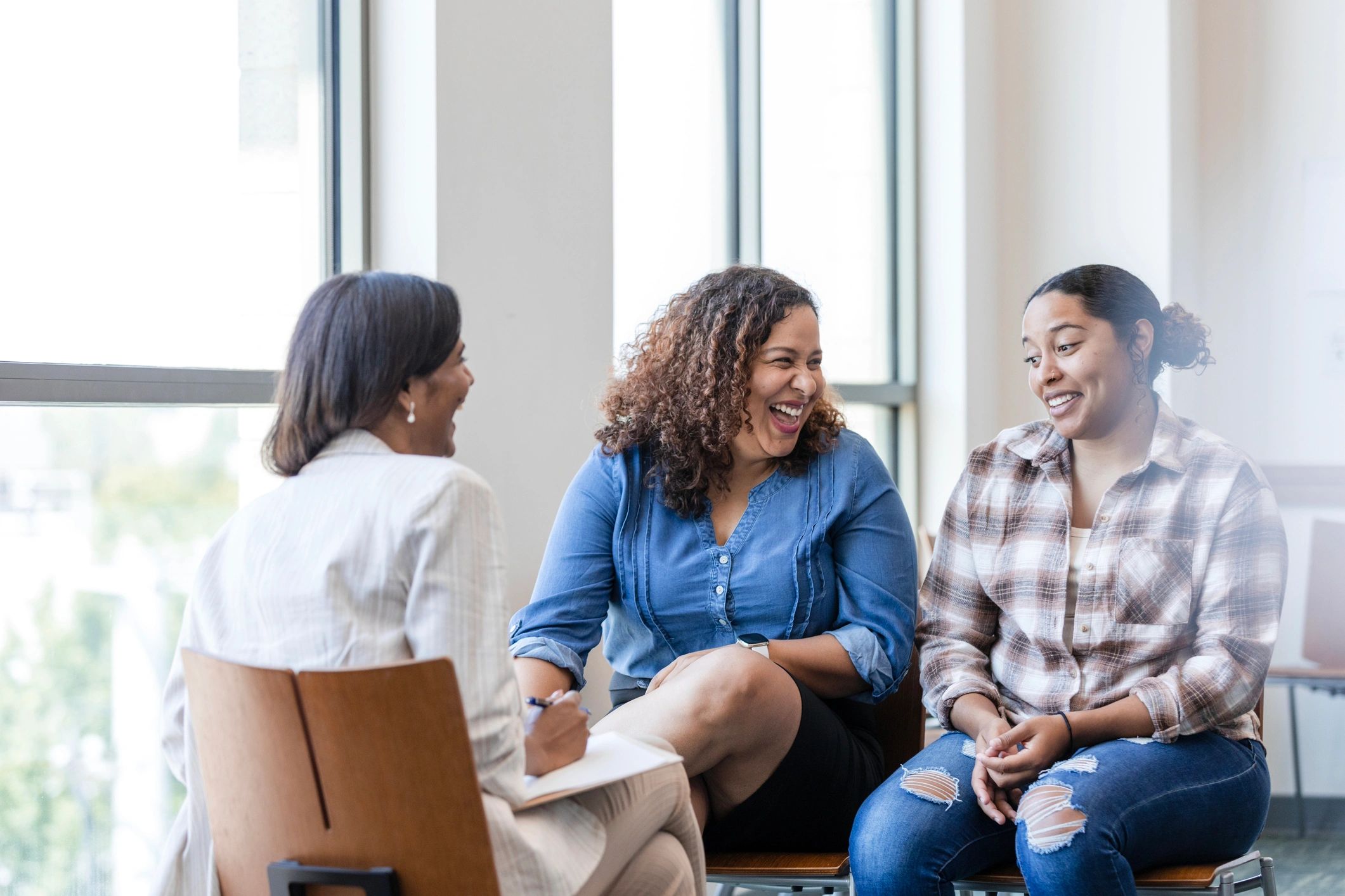 Family listening and talking together with a facilitator during a supportive meeting